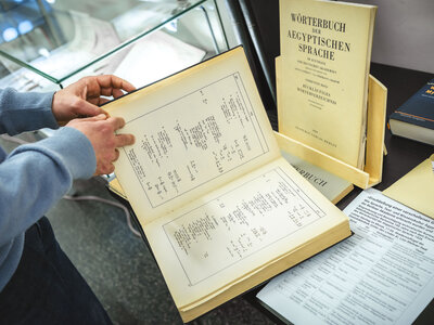 Eine Person blättert durch das "Wörterbuch der Aegyptischen Sprache"